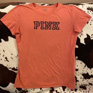 PINK tee , maybe coral in color with black writing size small